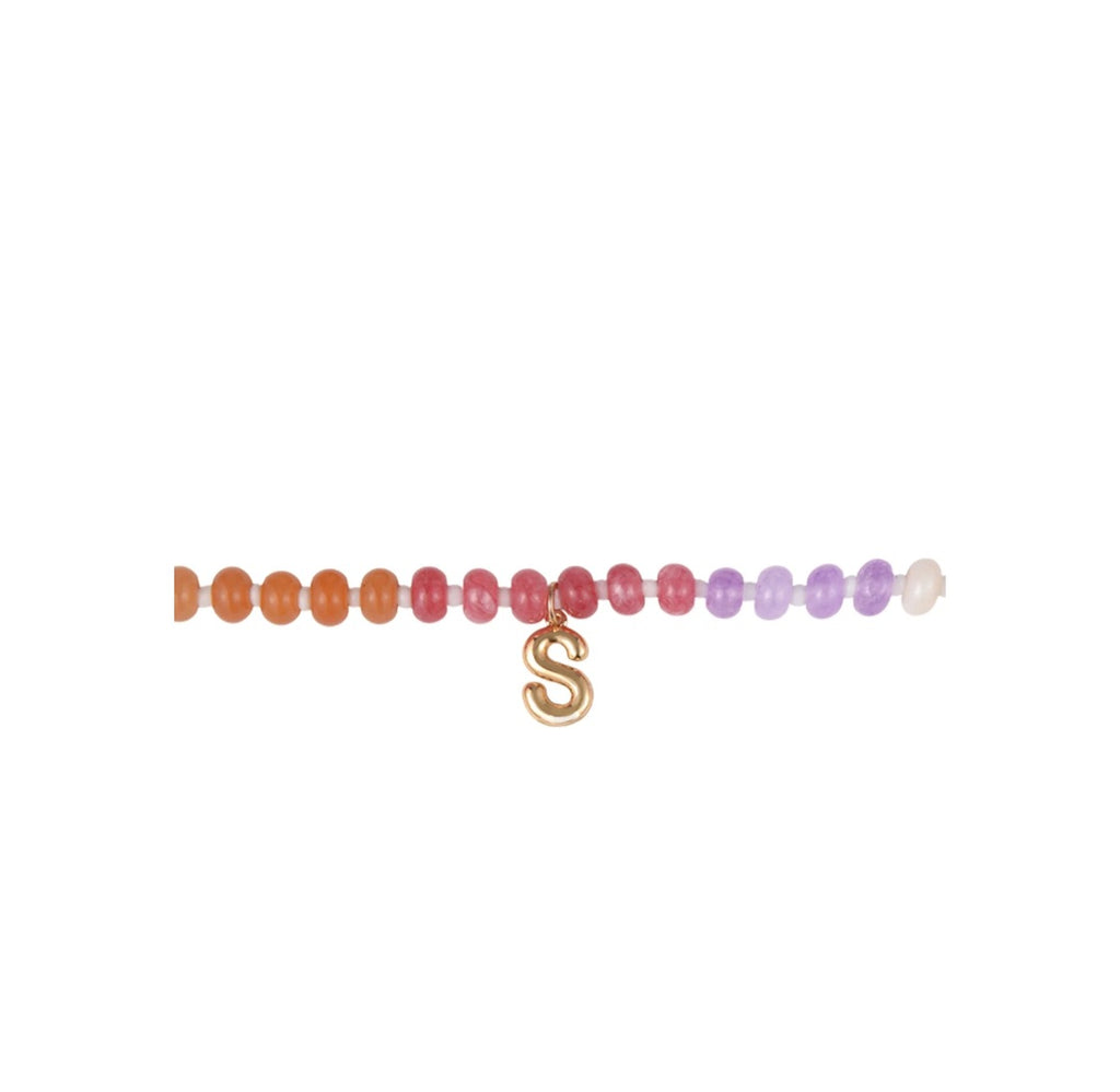 Multicolored beaded bracelet with a gold 'S' charm on a white background