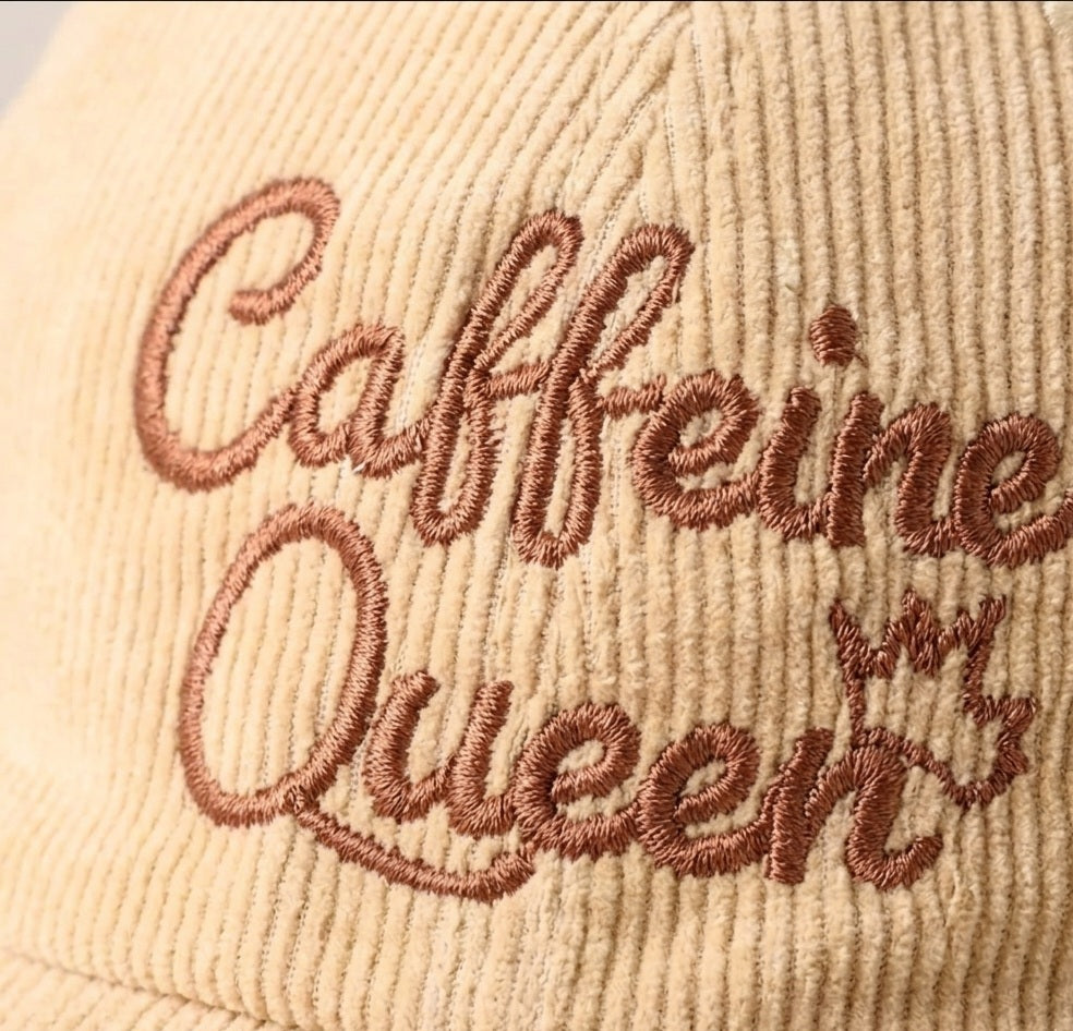 Beige cap with 'Caffeine Queen' embroidery on a beige background