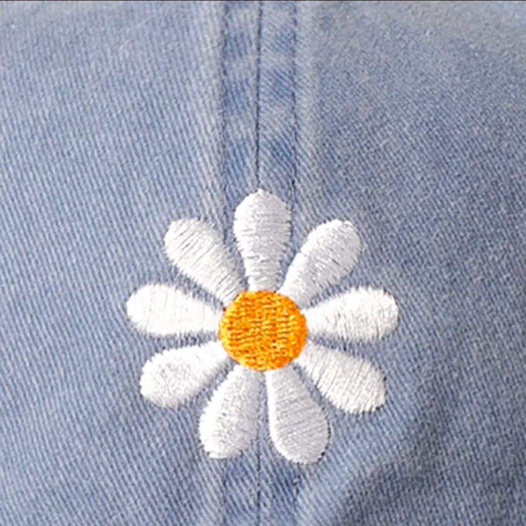 Embroidered daisy flower on a denim fabric background