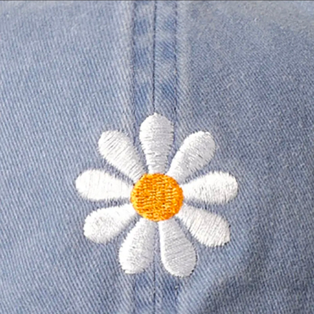 Embroidered daisy flower on a denim fabric background