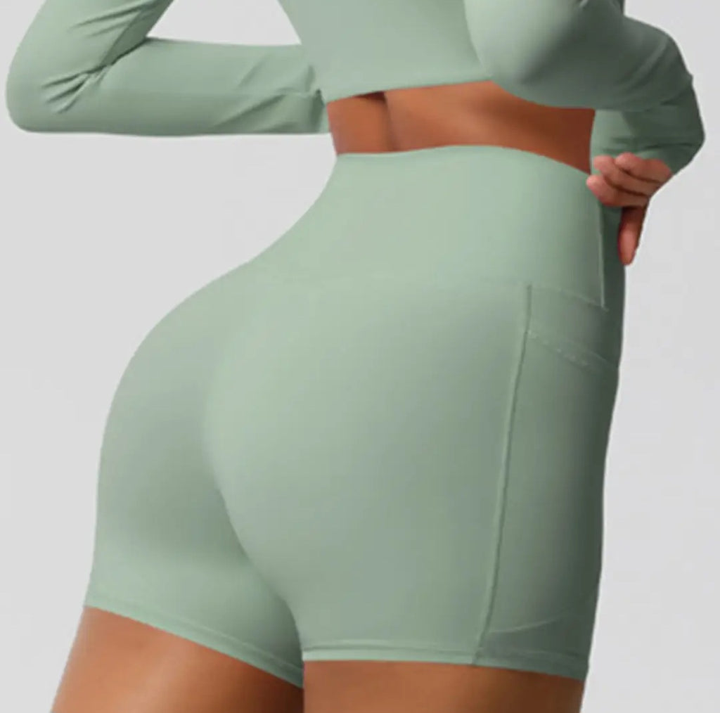 Green athletic shorts worn by a person on a plain background