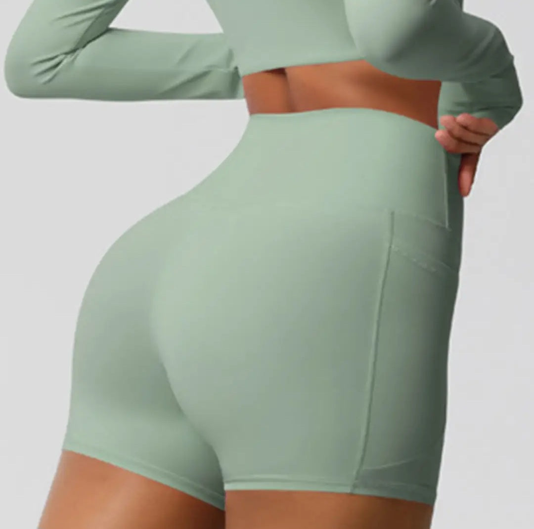 Green athletic shorts worn by a person on a plain background