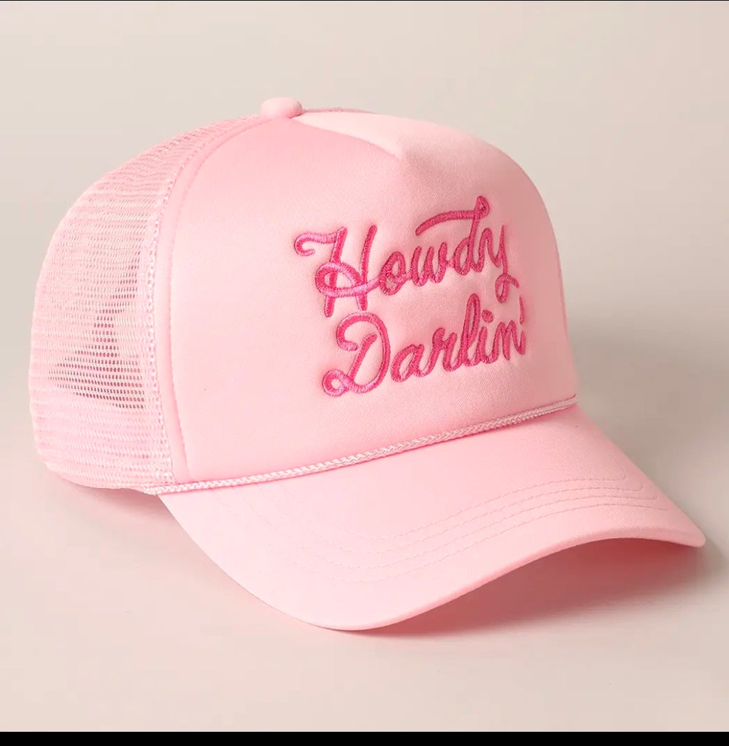 Pink cap with 'Howdy Darlin' text on a beige background