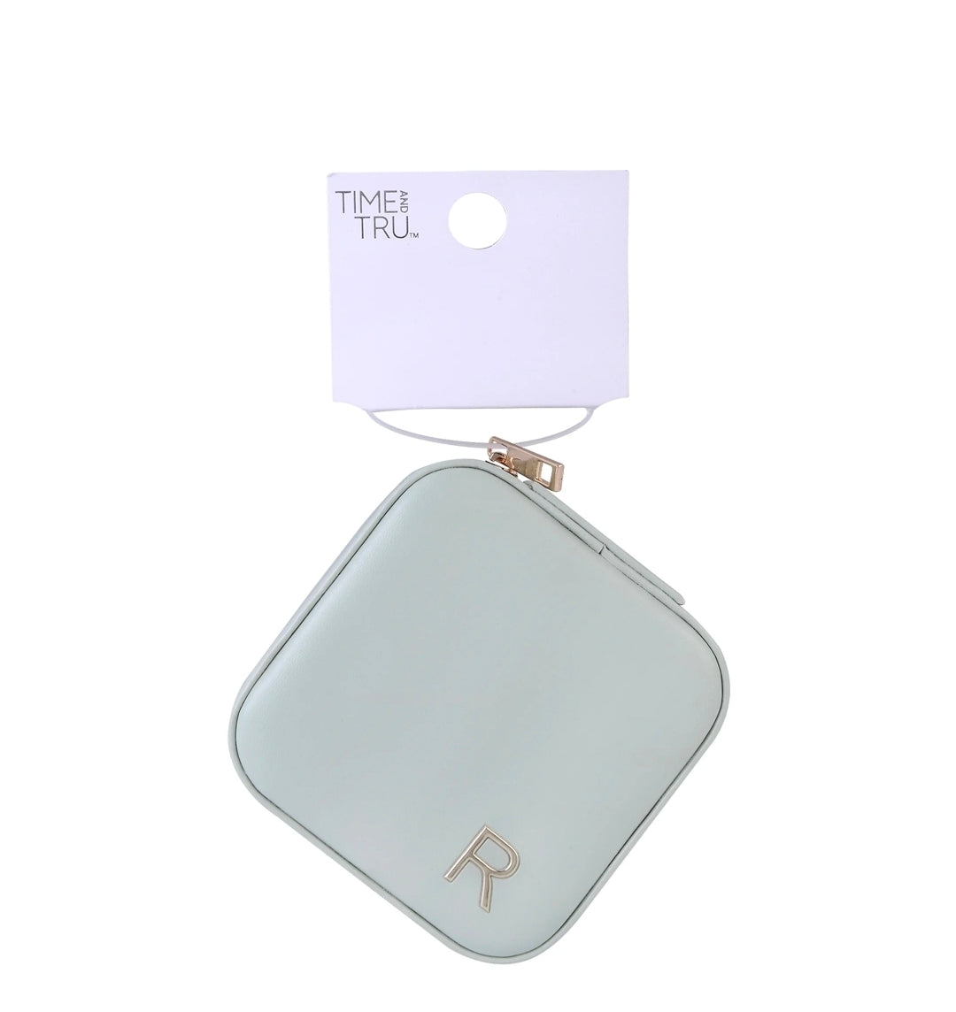 A small square coin purse in a pale mint green color with rounded corners, featuring a gold 'R' logo on the front. It is shown hanging from a white paper display card with the brand name 'TIME & TRUL' printed on it, set against a plain white background.