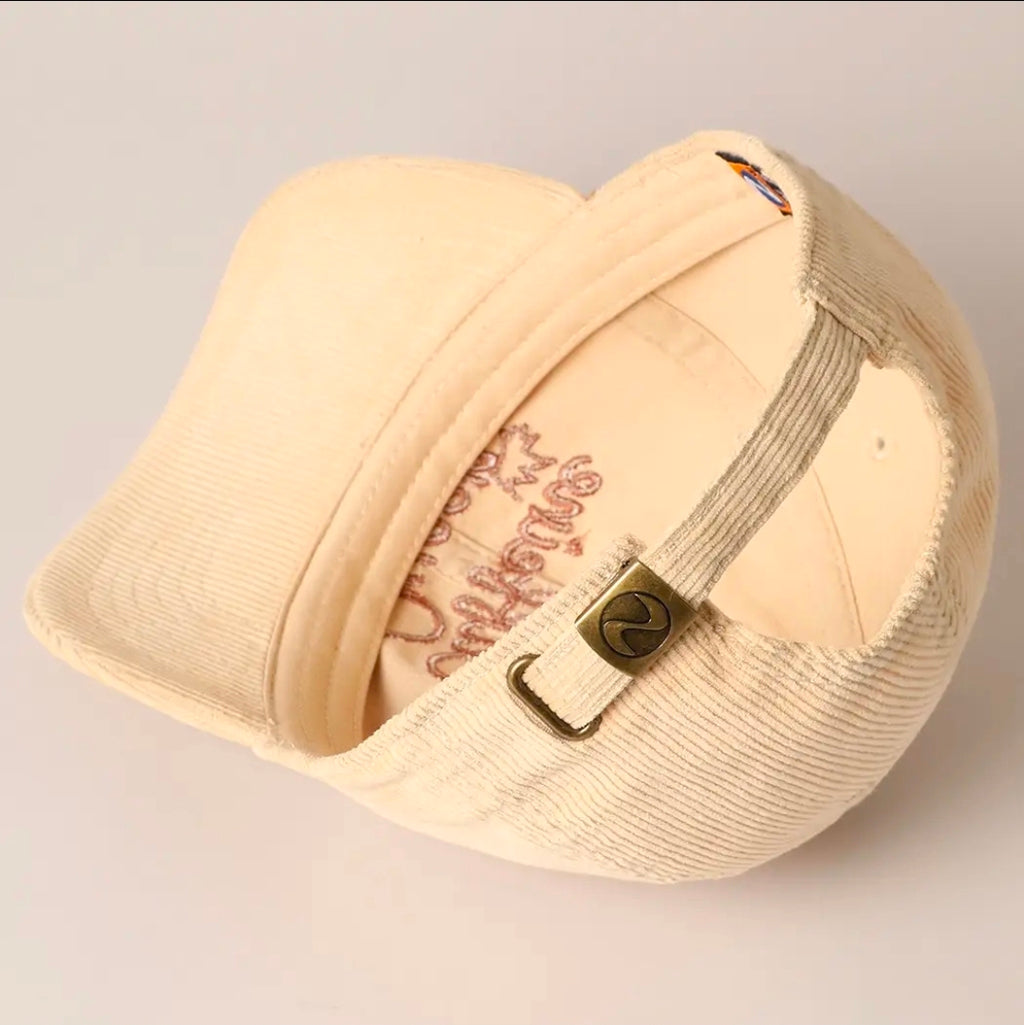Beige cap with branding on a light gray background