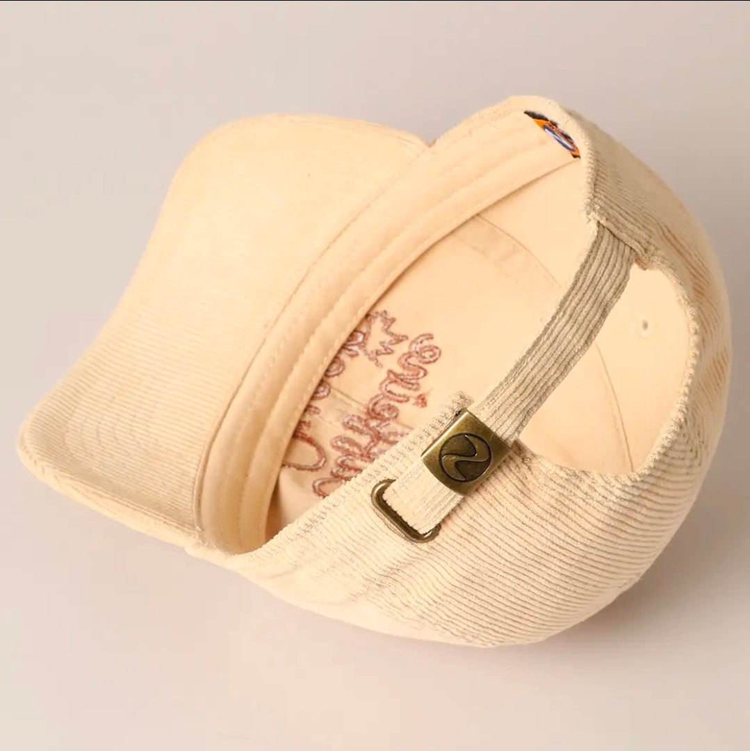 Beige cap with branding on a light gray background